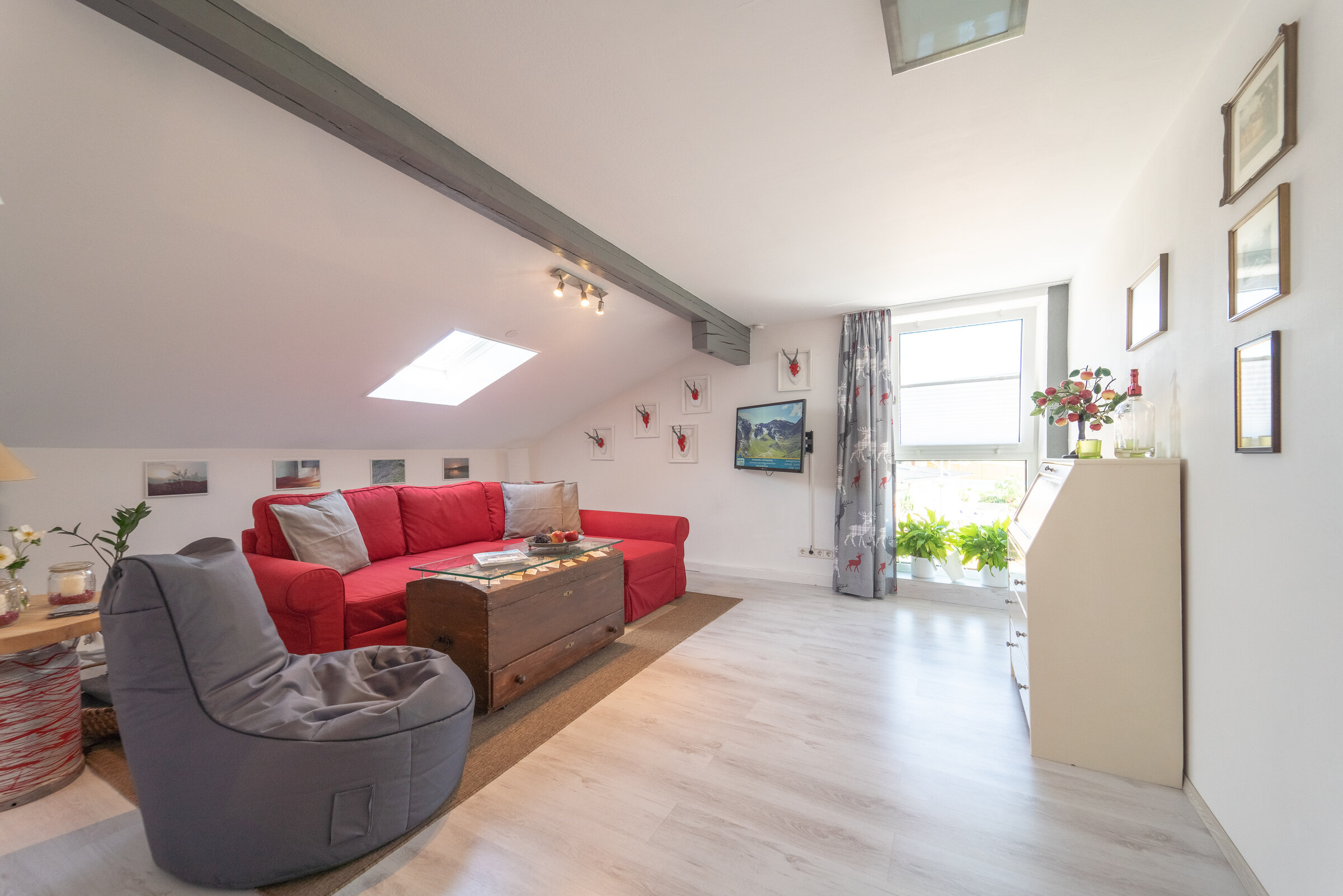 Bright living room with sloped ceiling & skylight – 2-room apt for short-term rental & temporary housing 1–6 months, Seekirchen