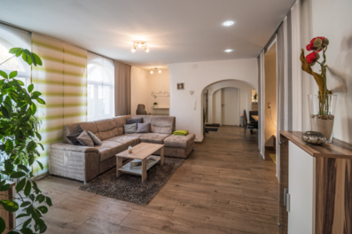 Bright open living area with wood floors & sofa – 2-room apartment for short-term rental & temporary housing for 1 to 6 months in Seekirchen