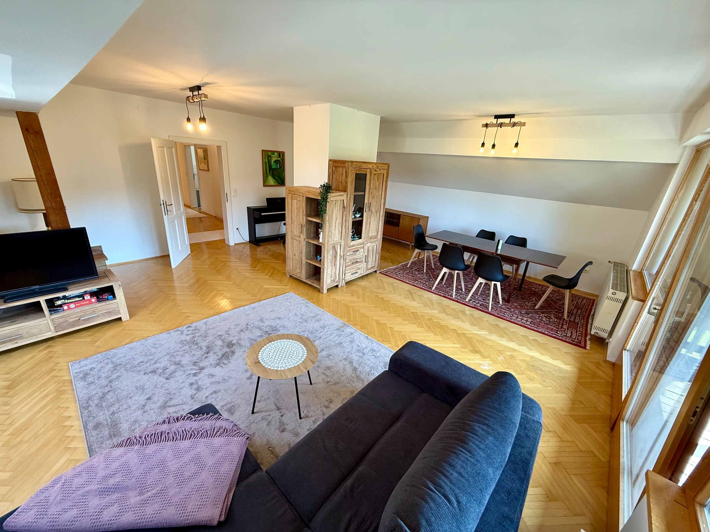 Helles Wohnzimmer mit Parkett, Essbereich & Sofa – 4-Zimmer Wohnung, Kurzzeitmiete Graz, Wohnen auf Zeit für 1 bis 6 Monate