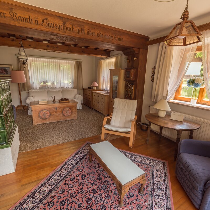 Wohnzimmer mit Kachelofen & Holzboden – 2-Zimmer Wohnung, Kurzzeitmiete & Wohnen auf Zeit für 1 bis 6 Monate in Grünau