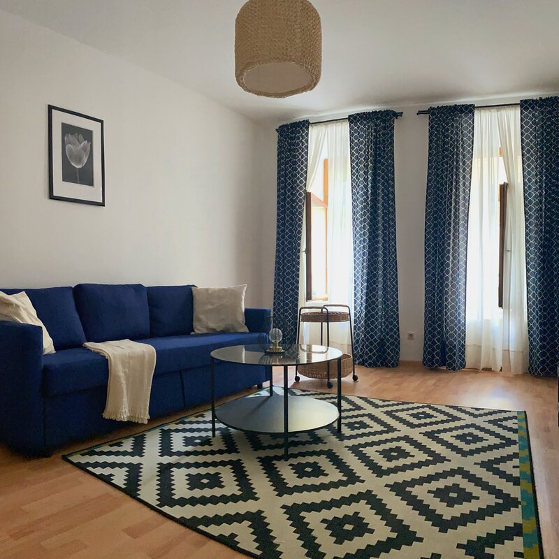 Bright living room, blue sofa & modern decor – 2-room apartment for short-term rental in Vienna, 1 to 6 months | © dilachio