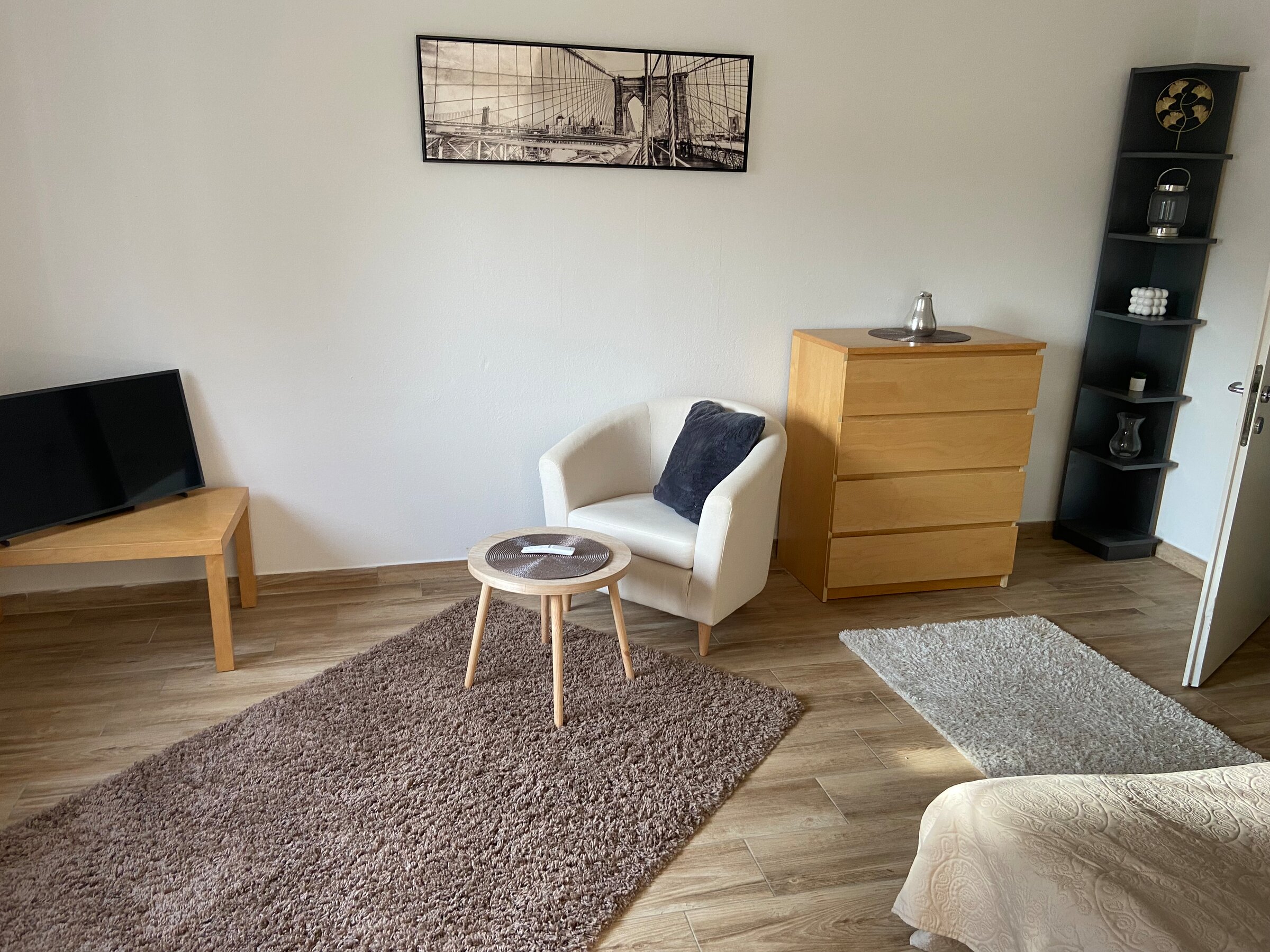 Bright living room with TV & armchair – 3-room apartment, short-term rental & temporary housing for 1 to 6 months in Linz