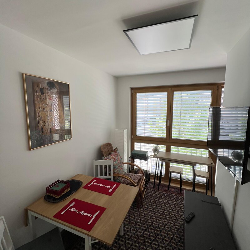 Zimmer mit Esstisch, Schreibtisch und Entspannungsecke