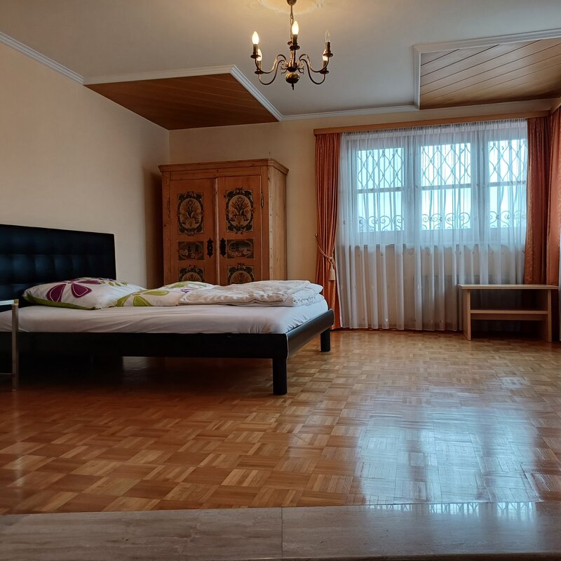 Helles Schlafzimmer mit Parkettboden & Holzschrank – 2-Zimmer-Wohnung, Kurzzeitmiete & Wohnen auf Zeit für 1 bis 6 Monate in Wals