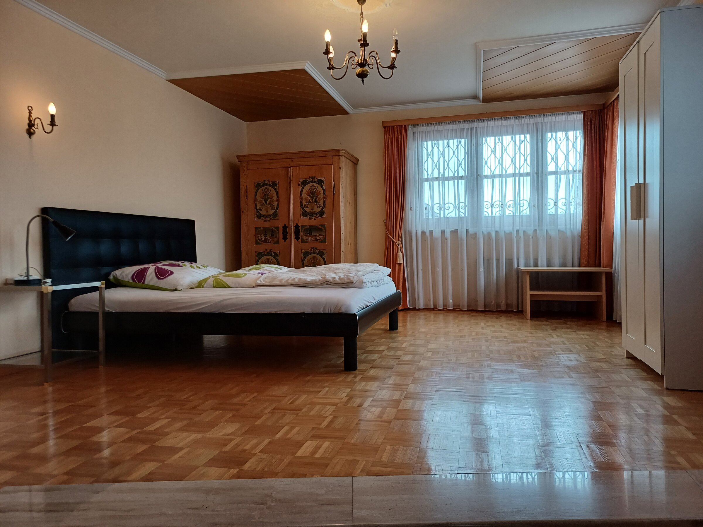 Helles Schlafzimmer mit Parkettboden & Holzschrank – 2-Zimmer-Wohnung, Kurzzeitmiete & Wohnen auf Zeit für 1 bis 6 Monate in Wals