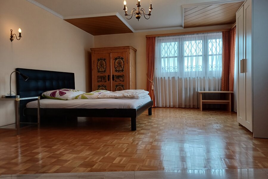Helles Schlafzimmer mit Parkettboden & Holzschrank – 2-Zimmer-Wohnung, Kurzzeitmiete & Wohnen auf Zeit für 1 bis 6 Monate in Wals
