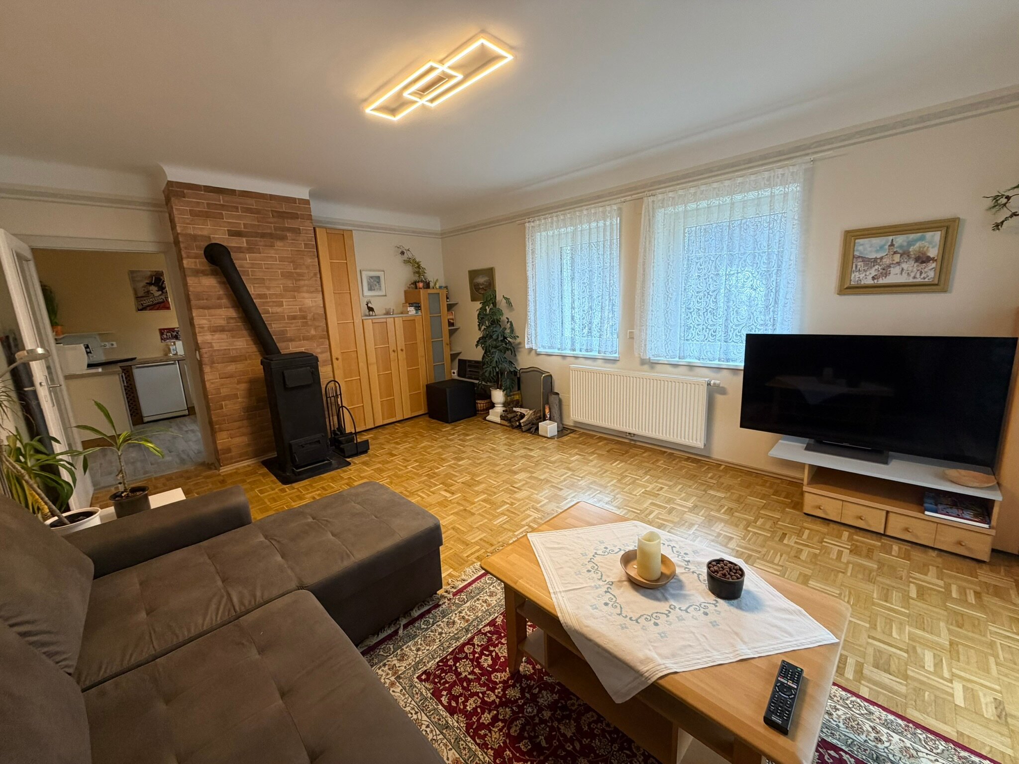 Wohnzimmer mit Kaminofen & Parkett – 2-Zimmer Wohnung, Kurzzeitmiete & Wohnen auf Zeit für 1 bis 6 Monate in Purkersdorf