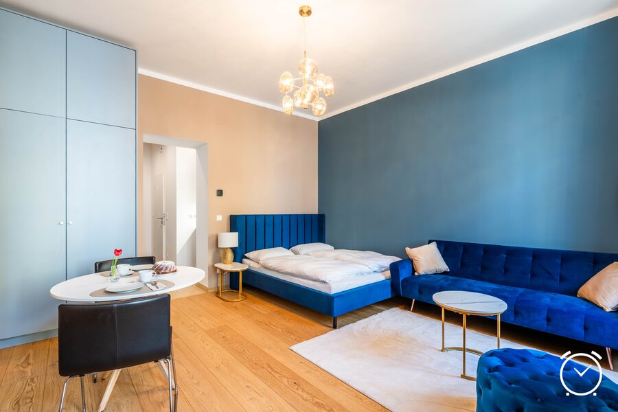 Großzügiger, modern eingerichteter Wohnbereich mit bequemem Bett, Sofa und Essplatz. Helles Design mit viel Tageslicht für einen entspannten Aufenthalt in Wien.