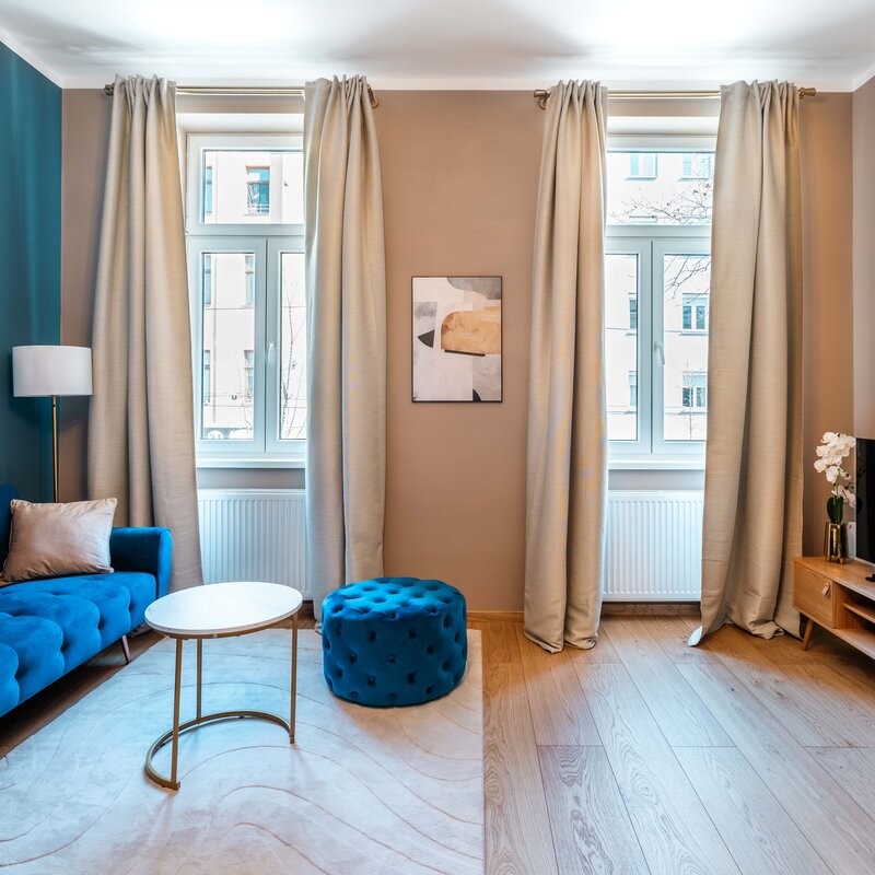 Großzügiger und lichtdurchfluteter Wohnbereich mit bequemem Sofa, TV und stilvoller Einrichtung – perfekt zum Entspannen nach einem Tag in Wien.