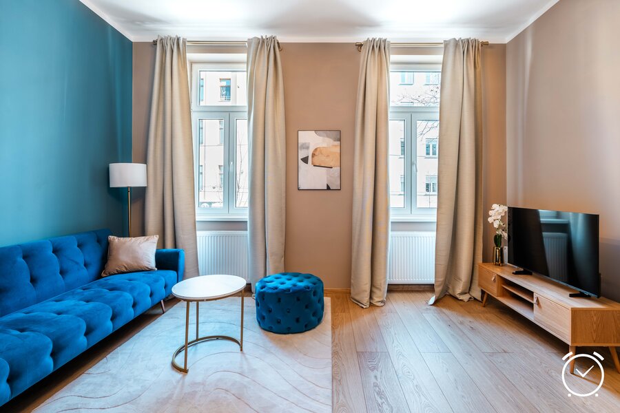 Großzügiger und lichtdurchfluteter Wohnbereich mit bequemem Sofa, TV und stilvoller Einrichtung – perfekt zum Entspannen nach einem Tag in Wien.
