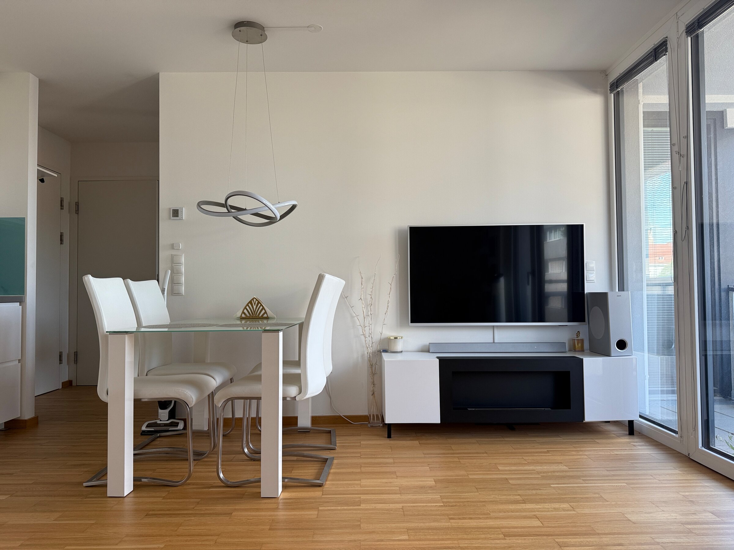 Heller Wohn-Essbereich mit Glasetisch & TV – 2-Zimmer Wohnung, Kurzzeitmiete & Wohnen auf Zeit 1–6 Monate, Wien