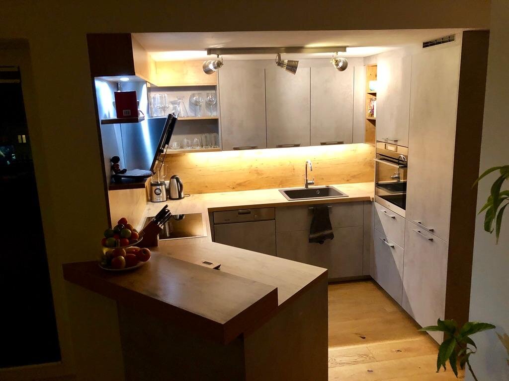 Kitchen with breakfast bar, induction cooktop, dishwasher, large refrigerator and freezer compartment | © Karin Hollenstein