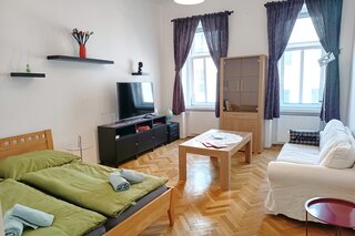 Wohnzimmer mit Doppelbett, Smart TV und Sofa