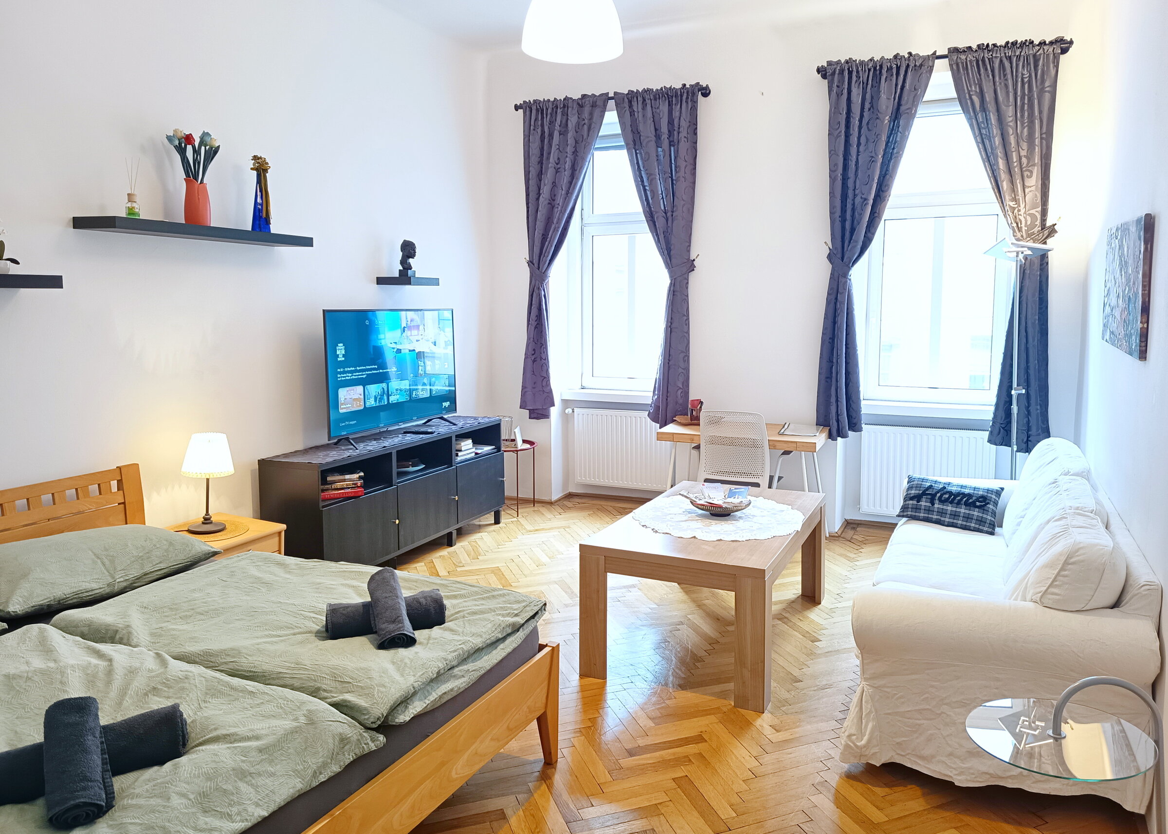 Wohnzimmer mit Doppelbett, Smart TV, Sofa, Arbeitsplatz