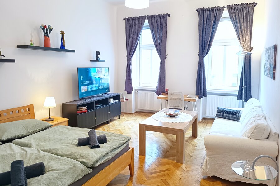 Wohnzimmer mit Doppelbett, Smart TV, Sofa, Arbeitsplatz