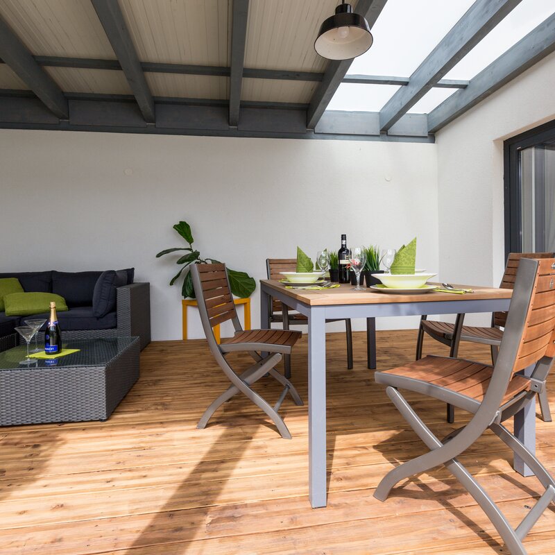 Die Terrase ist zum Innenhof hin offen, rechts die Glastüre zum Wohnzimmer