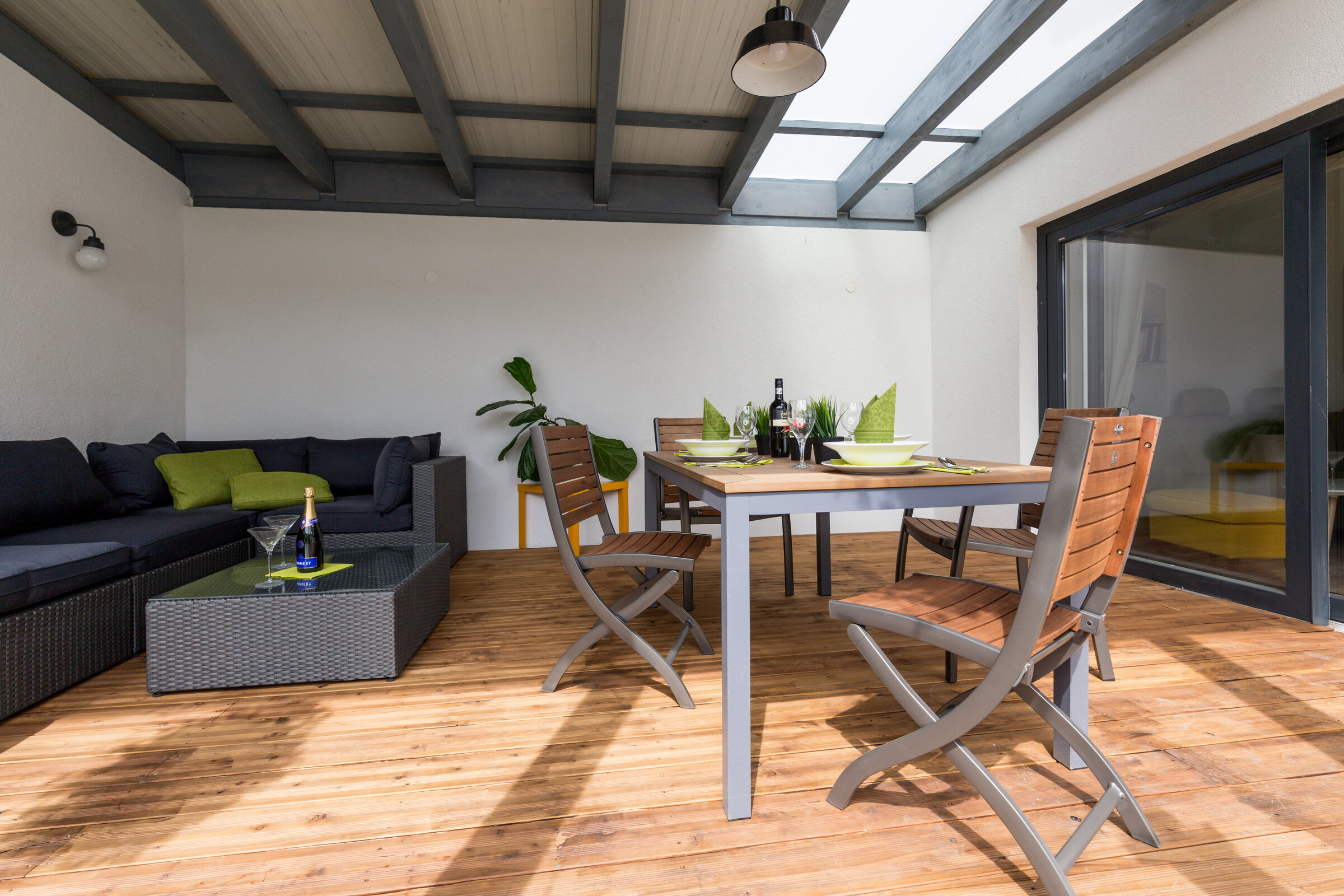 Die Terrase ist zum Innenhof hin offen, rechts die Glastüre zum Wohnzimmer