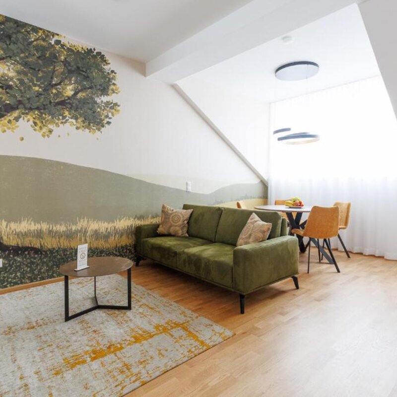 Helles Wohnzimmer mit Naturmotiv – 3-Zimmer Wohnung zur Kurzzeitmiete, Wohnen auf Zeit für 1 bis 6 Monate in Wien
