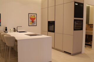 Die elegante Wohnküche kombiniert Design und Funktionalität – der integrierte Weinkühlschrank setzt ein exklusives Highlight und sorgt für stilvolle Genussmomente.