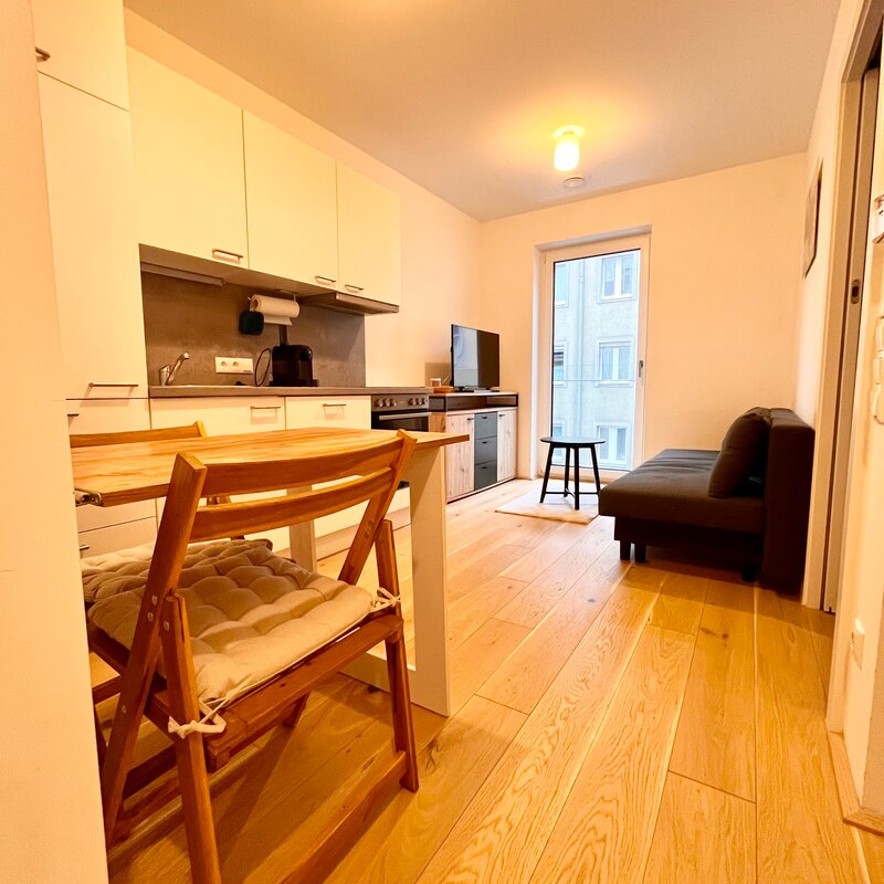 Helles Wohnzimmer mit Küche & Holzboden – 2-Zimmer Wohnung zur Kurzzeitmiete & Wohnen auf Zeit in Linz