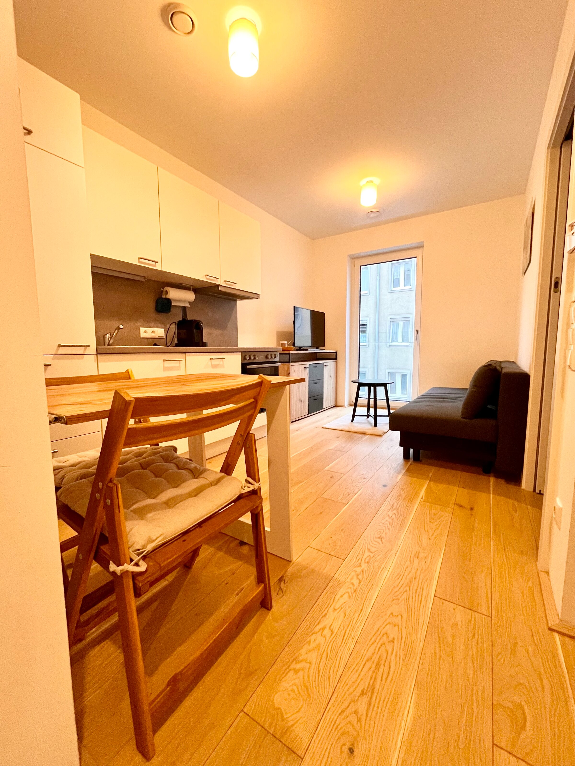 Helles Wohnzimmer mit Küche & Holzboden – 2-Zimmer Wohnung zur Kurzzeitmiete & Wohnen auf Zeit in Linz