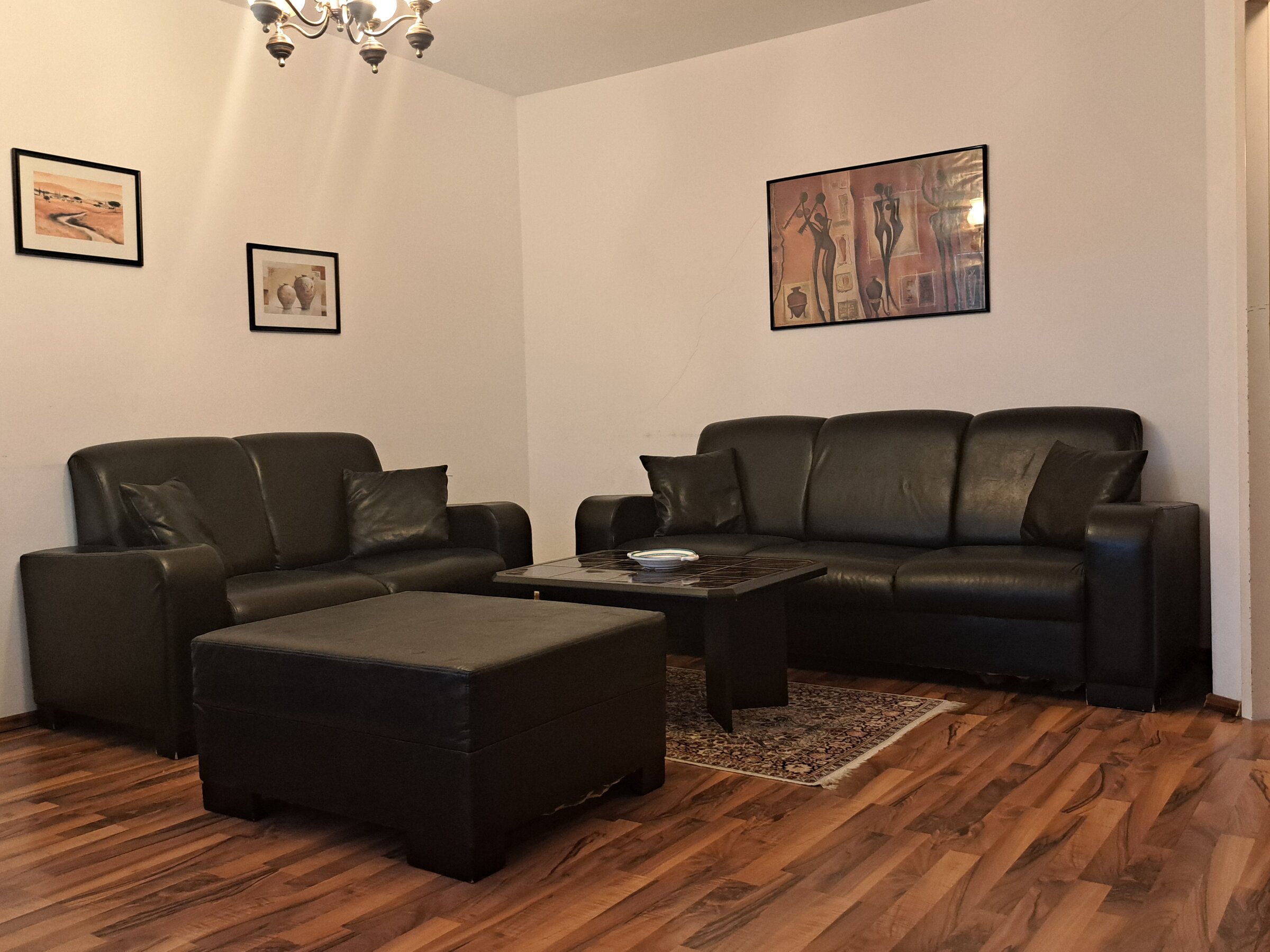 Helles Wohnzimmer mit schwarzen Ledersofas – 3-Zimmer Wohnung zur Kurzzeitmiete, Wohnen auf Zeit 1 bis 6 Monate, Wien
