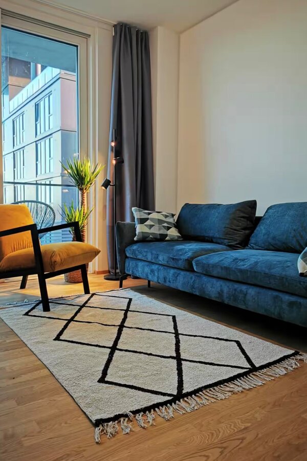 Helles Wohnzimmer mit Designmöbeln – 2-Zimmer-Wohnung zur Kurzzeitmiete & Wohnen auf Zeit für 1 bis 6 Monate in Wien | © Peter Pyka
