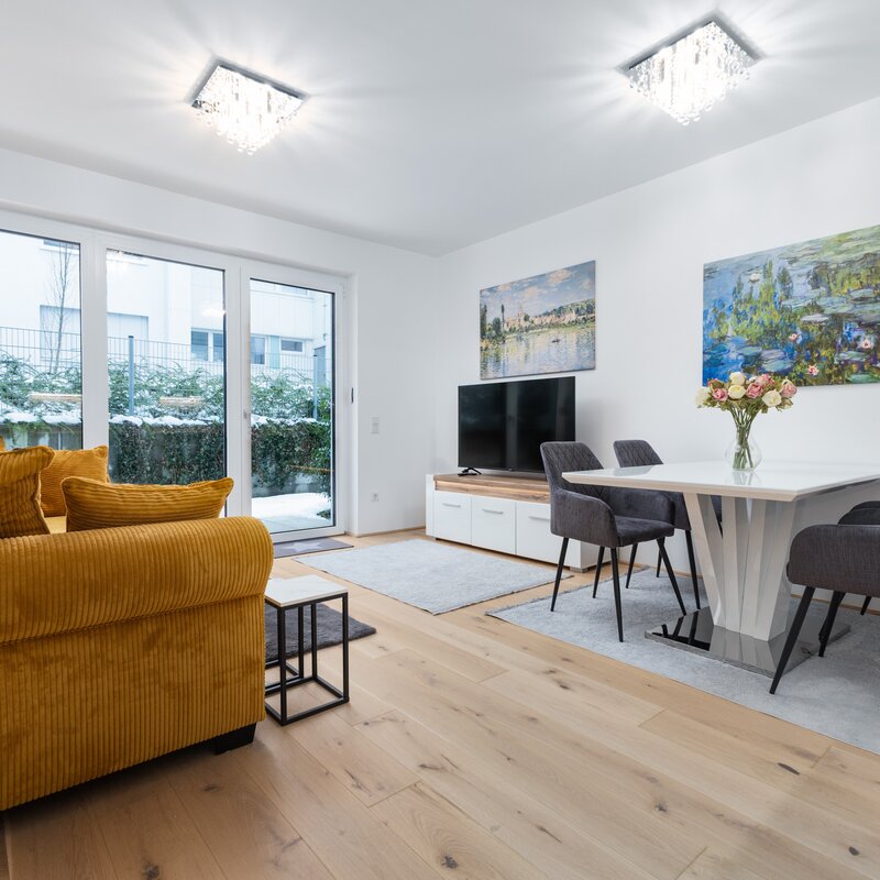 Bright living area with dining table & sofa – 2-room apartment, short-term rental Linz, temporary housing 1 to 6 months
