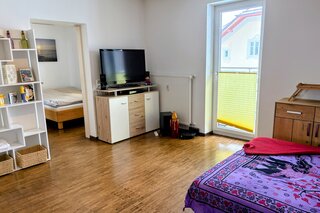 Wohnzimmer mit Zugang auf den Balkon | © JULIA KIEFHABER