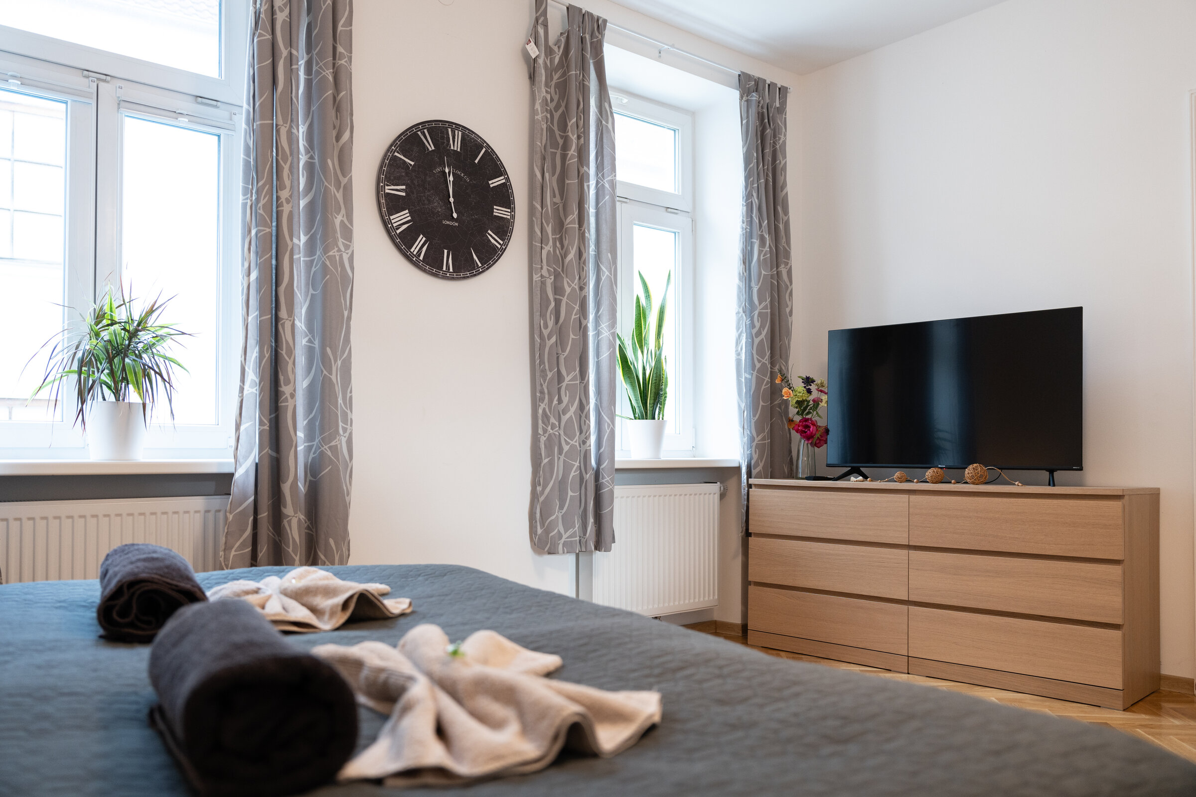 Bright bedroom with TV, dresser & plants – 3-room apartment for short-term rental & temporary housing 1 to 6 months in Eggenburg