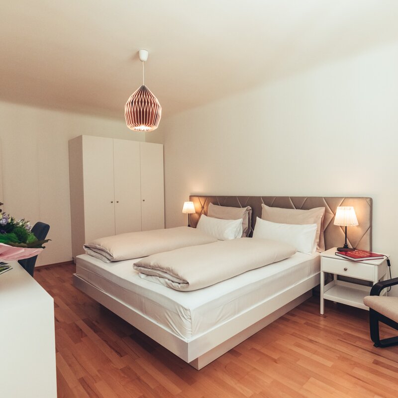 Schlafzimmer mit Schreibtisch linkls und Sessel
