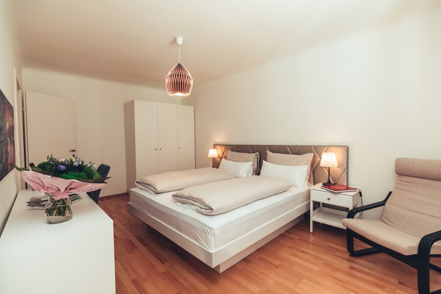 Schlafzimmer mit Schreibtisch linkls und Sessel