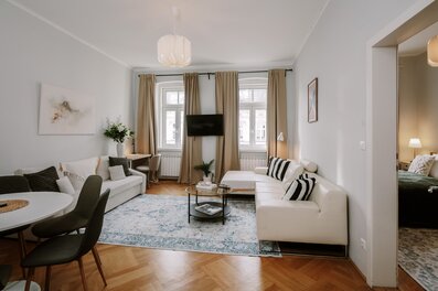 Heller Wohnbereich mit weißer Couch & Parkettboden – 3-Zimmer Wohnung, Kurzzeitmiete Wien, Wohnen auf Zeit 1 bis 6 Monate | © Apartment Care GmbH
