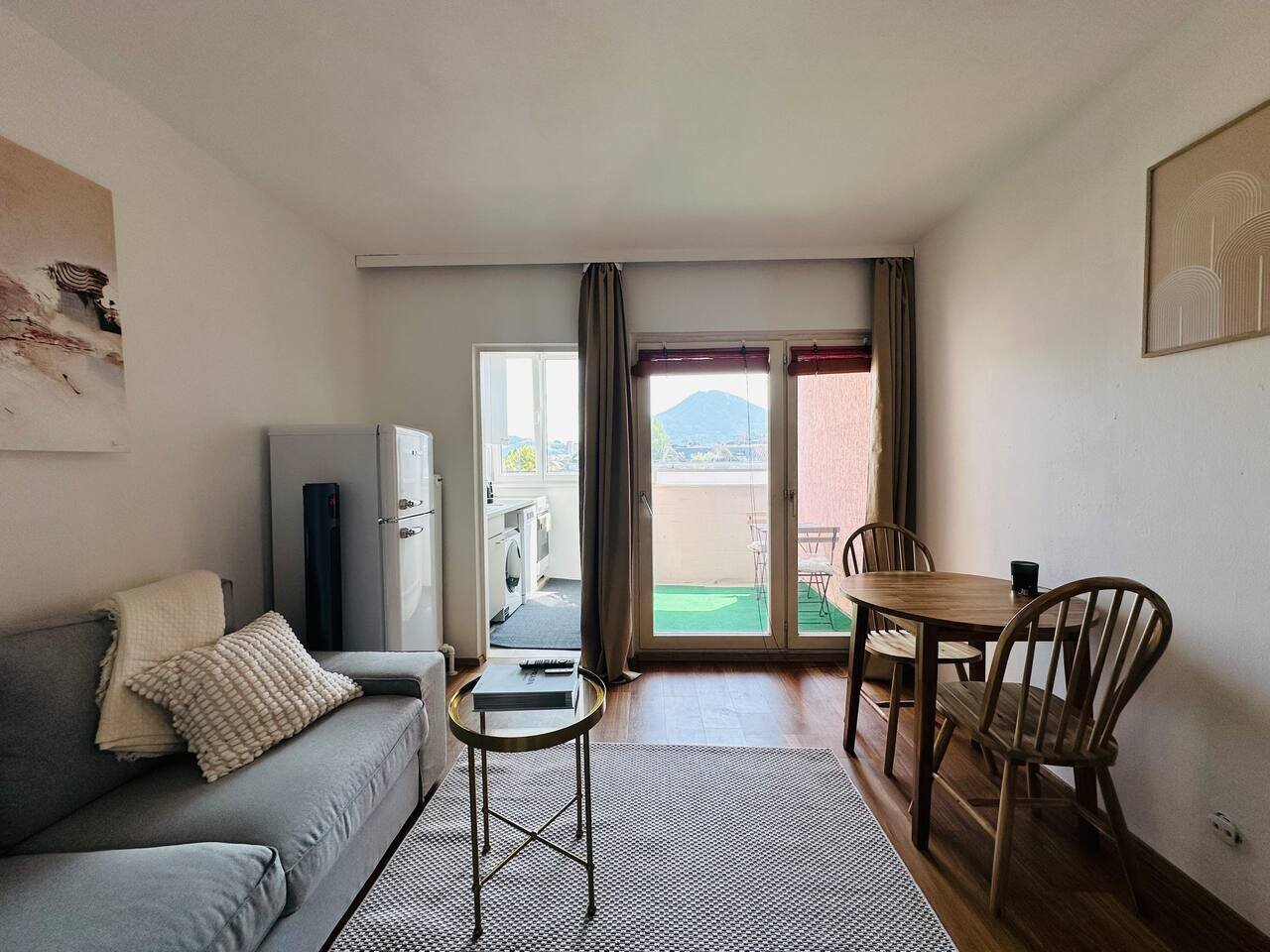 Bright living room with balcony & mountain view – 1-room apt, short-term rental & temporary housing for 1 to 6 months in Salzburg | © Apartment Care GmbH