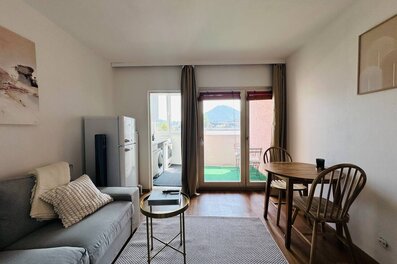 Bright living room with balcony & mountain view – 1-room apt, short-term rental & temporary housing for 1 to 6 months in Salzburg | © Apartment Care GmbH
