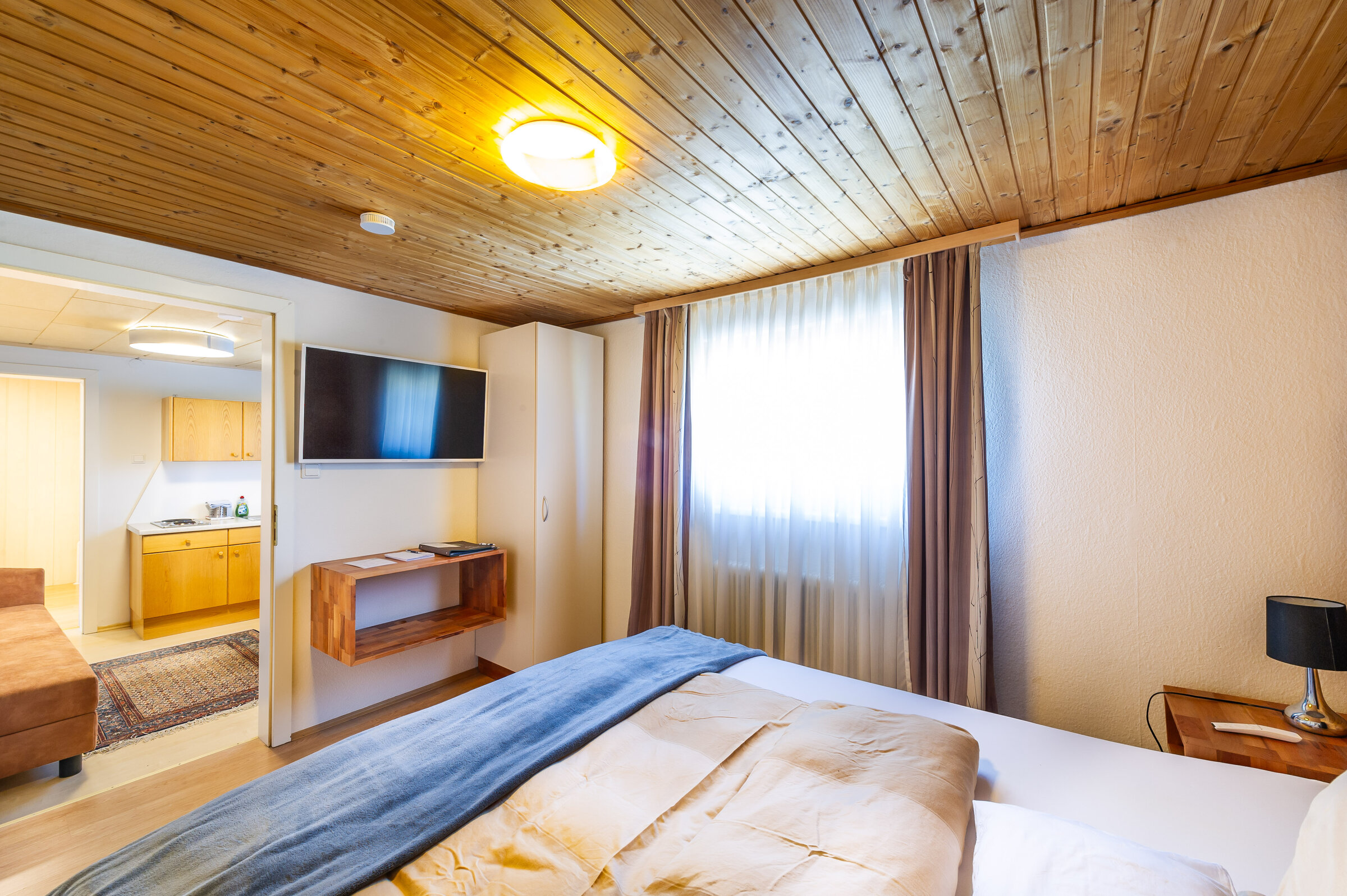 Bright bedroom with wood ceiling & TV in 2-room apartment – short-term rental & temporary housing for 1 to 6 months in Übelbach
