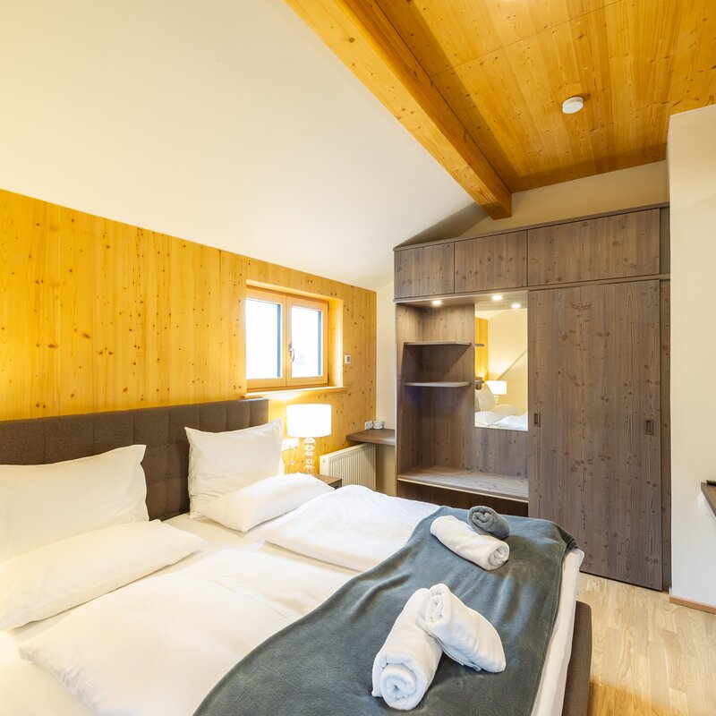 Bright bedroom with wood paneling in 2-room apartment – short-term rental & temporary housing for 1 to 6 months in Übelbach