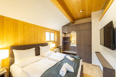Bright bedroom with wood paneling in 2-room apartment – short-term rental & temporary housing for 1 to 6 months in Übelbach