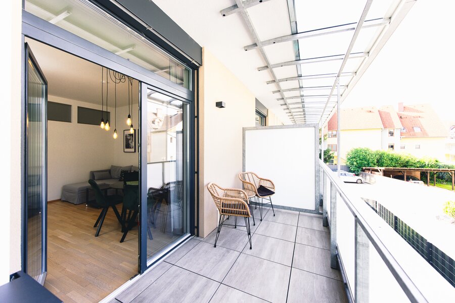 Überdachter Balkon mit Rattanstühlen – 2-Zimmer Wohnung, Kurzzeitmiete Graz, Wohnen auf Zeit für 1 bis 6 Monate