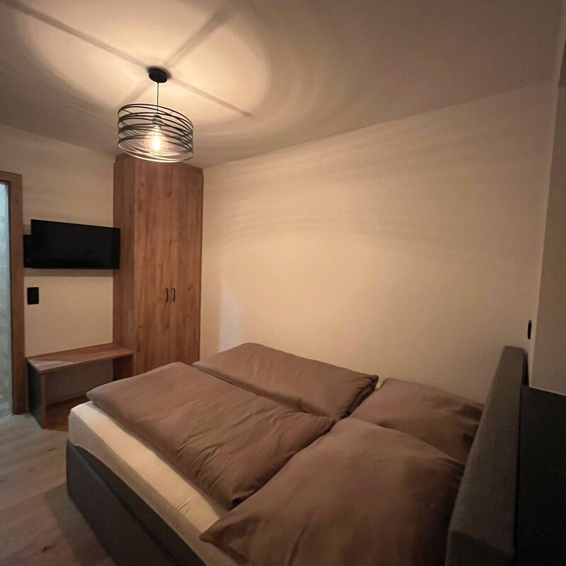 Schlafzimmer mit Kleiderschrank und Fernseher
