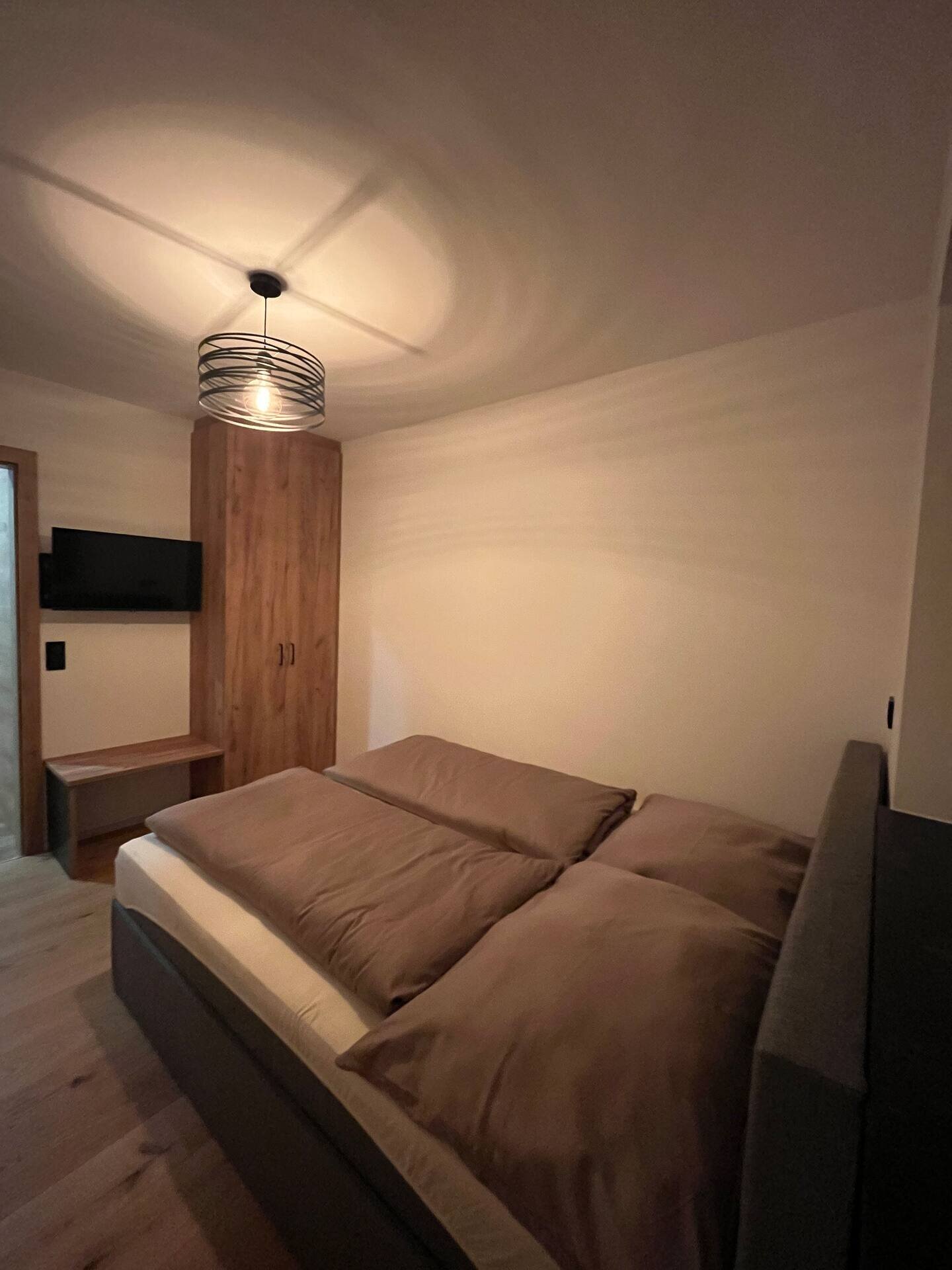 Schlafzimmer mit Kleiderschrank und Fernseher