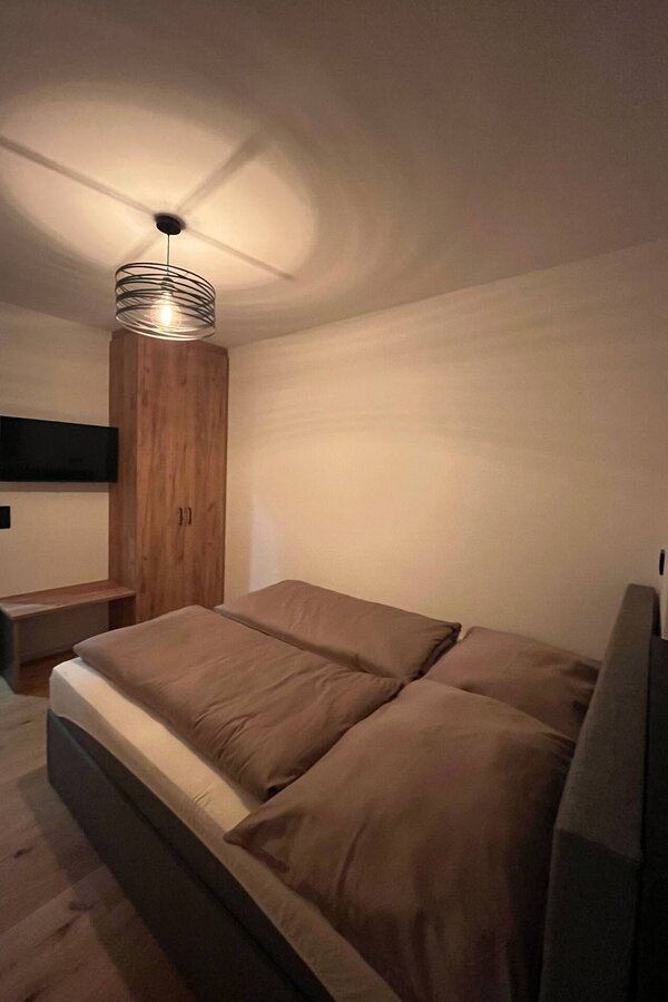 Schlafzimmer mit Kleiderschrank und Fernseher