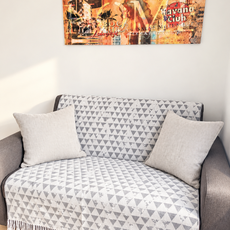 Diese gemütliche Sitzecke lädt zum Entspannen ein. Das Sofa mit dekorativen Polstern schafft zusammen mit dem warmen Ambiente einen angenehmen Rückzugsort zum Lesen oder Ausruhen.