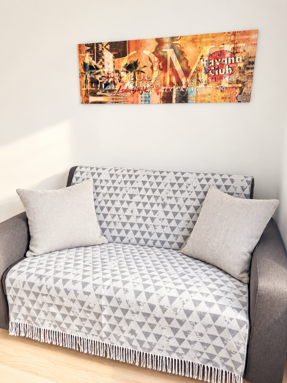 Diese gemütliche Sitzecke lädt zum Entspannen ein. Das Sofa mit dekorativen Polstern schafft zusammen mit dem warmen Ambiente einen angenehmen Rückzugsort zum Lesen oder Ausruhen.