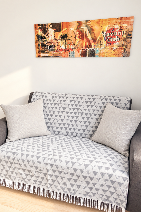 Diese gemütliche Sitzecke lädt zum Entspannen ein. Das Sofa mit dekorativen Polstern schafft zusammen mit dem warmen Ambiente einen angenehmen Rückzugsort zum Lesen oder Ausruhen.