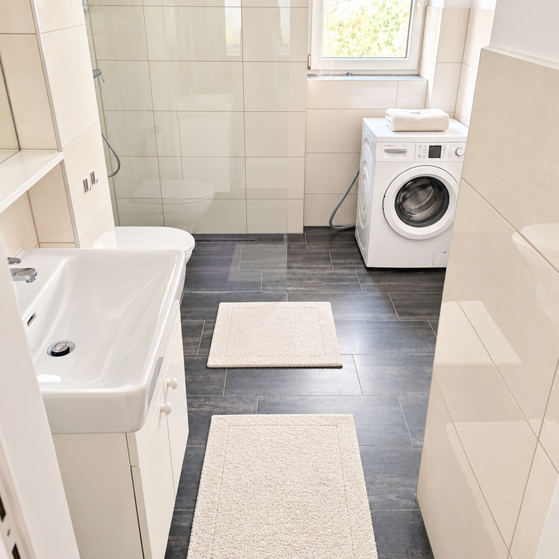 Das gepflegte Badezimmer ist hell und freundlich gestaltet und verfügt über Dusche, Waschbecken, WC und Waschmaschine.