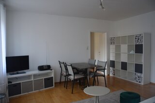 Wohnzimmer mit Sofa, Esstisch, TV