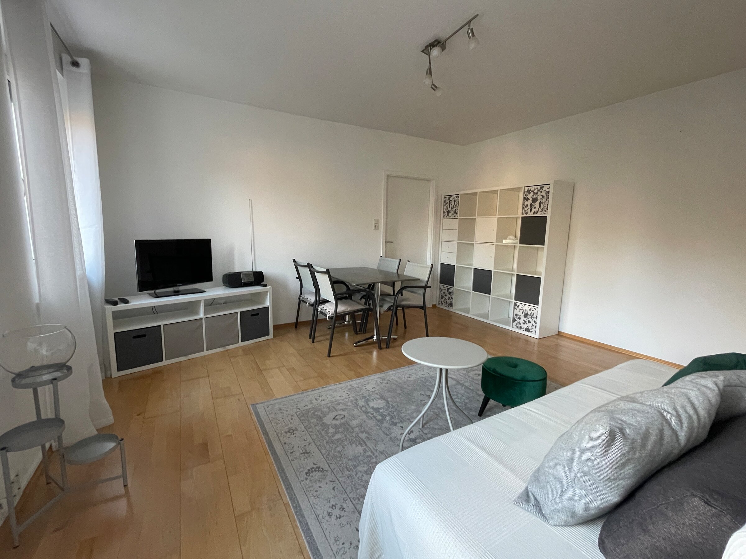 Wohnzimmer mit Sofa, Esstisch, TV