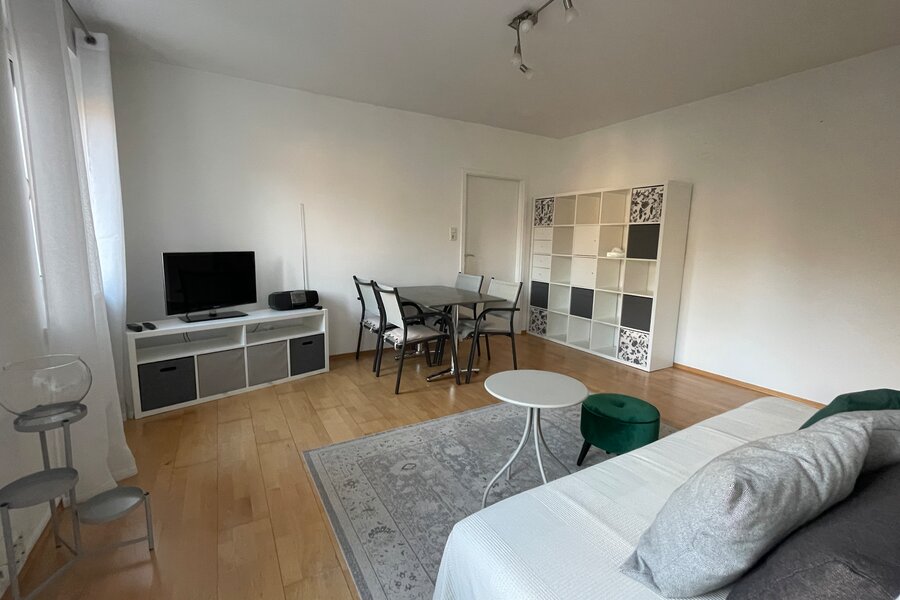 Wohnzimmer mit Sofa, Esstisch, TV