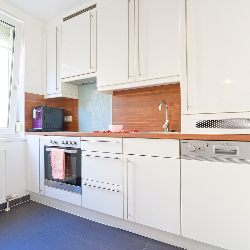 Küche mit E-Herd, Kaffeemaschine, Kühlschrank und Gefrierfach